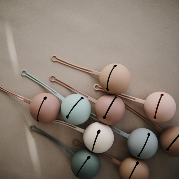 Mushie Dummy Case in blush, durable BPA-free silicone design, holds up to 3 dummies with a convenient strap for on-the-go storage.