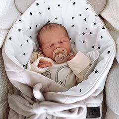 Spoiltland velvet swaddle blanket in sand wrapped around sleeping newborn baby