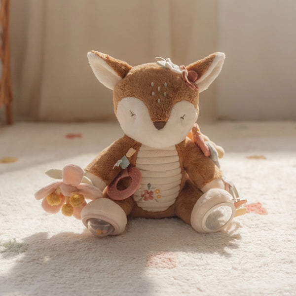 Stuffed deer toy with flowers on a soft surface