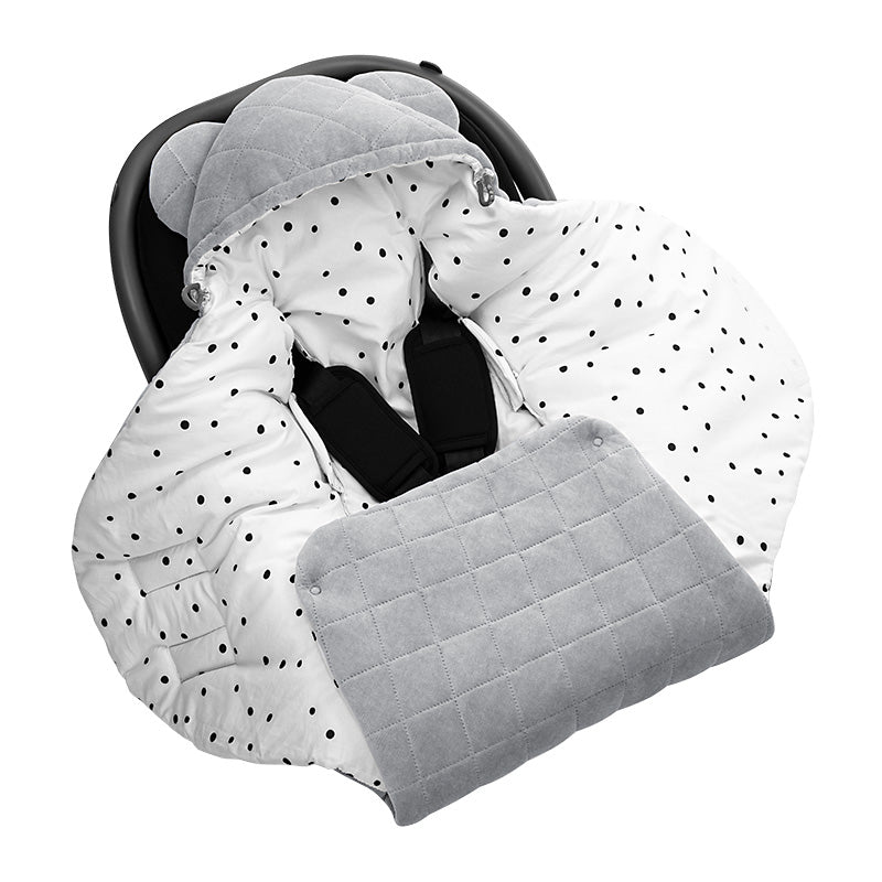 A gray car seat blanket with black dots pattern, placed on a car seat, designed to keep a baby warm.
